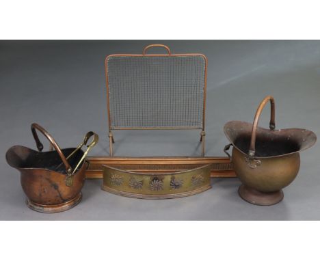 Two 19th century copper helmet-shaped coal scuttles; two pierced brass fenders; a mesh firescreen; &amp; pair of coal tongs.