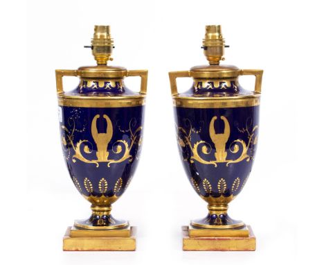 A PAIR OF TABLE LAMPS constructed from French porcelain urns, of blue ground with parcel gilt ornamentation, 31cm high to the