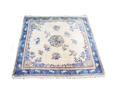 AN EASTERN BLUE AND CREAM GROUND SMALL CARPET with a banded border and foliate decoration, having a Maple &amp; Co label, 342