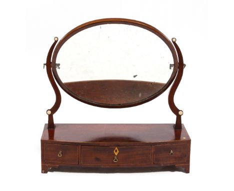 A 19TH CENTURY MAHOGANY BOW FRONTED DRESSING TABLE MIRROR with oval mirror plate, the base with three drawers and standing on