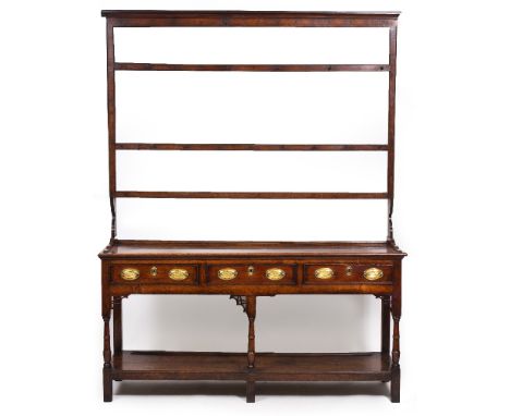 A 19TH CENTURY OAK DRESSER with three shelf plate rack above, the base with three drawers over turned legs united by an under