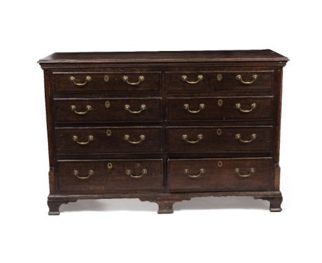 AN ANTIQUE OAK CHEST OF EIGHT DRAWERS with brass swan neck handles and raised on ogee bracket feet, 160cm wide x 60cm deep x 