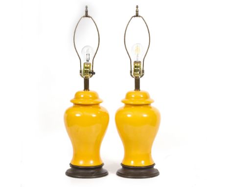 A PAIR OF MODERN TABLE LAMPS with yellow ground porcelain bodies, on circular plinths, 46cm high to the light fitting Conditi