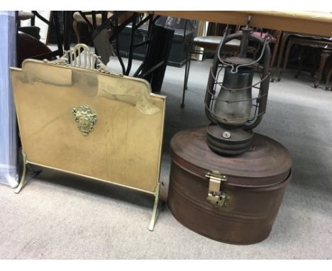 A Victorian metal hat tin with a brass hook, hurricane lamp and a brass fire screen.