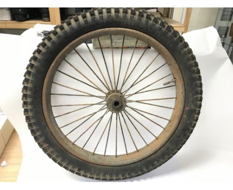 A pair of vintage wheels, likely for a motorbike, one with Dunlop rubber, the other with Firestone.