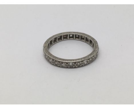 A platinum eternity ring set with small diamonds, approx 3.1g and approx size K.