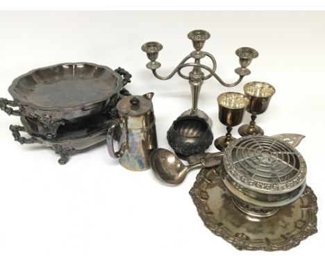 A collection of silver plate comprising two Victorian hot plates with scroll feet serving cutlery a ladle and other items.