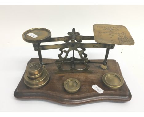 A set of vintage brass postal scales with brass weights.
