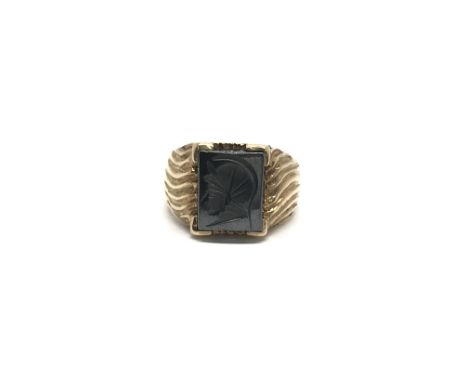 A 9ct gold ring set with an intaglio haematite, depicting a Trojan type portrait. Ring size approx S/T, total weight approx 7