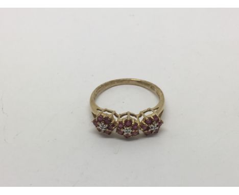 A 9ct gold ring set with rubies and diamonds in the form of three flowerheads, approx size P and approx 2.5g.