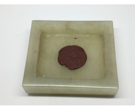 A white jade buckle with stylisised carving and red seal mark 5 cm by 5 cm