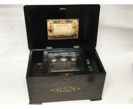 A Victorian inlaid Rosewood musical box playing eight airs. Playing on three bells with orgional tune label. Seen working. Ca