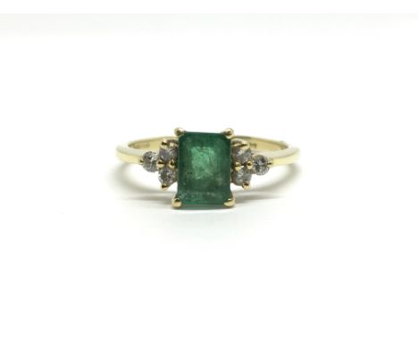 An 18ct yellow gold ring set with a central emerald flanked by three diamonds to each side. Total weight approx 2.7 grams, ri