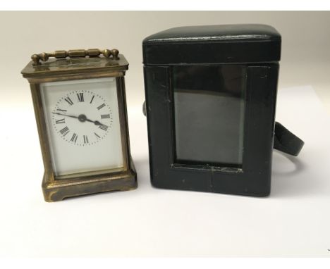 A brass cased carriage clock in a leather case.