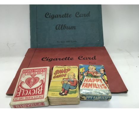 Two cigarette card albums and three packs of playing cards