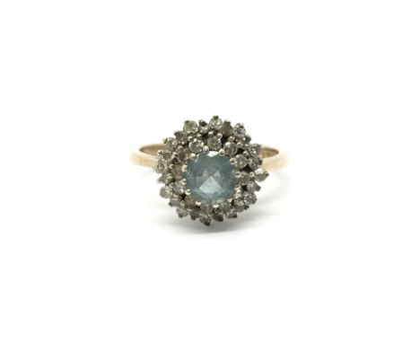 A 9ct gold ring set with a central aquamarine stone and two tiers of diamonds. Total weight approximately 2.5 grams, ring siz