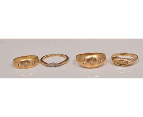 18ct hallmark gold three stone gypsy set diamond ring, and three other 18ct diamond set rings (one with a stone missing).