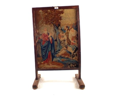 A fire screen with biblical woolwork tapestry