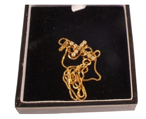 An 18ct gold white stone set cross on 18ct gold chain
