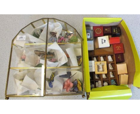 A display case of decorative ceramic butterflies plus various thimbles