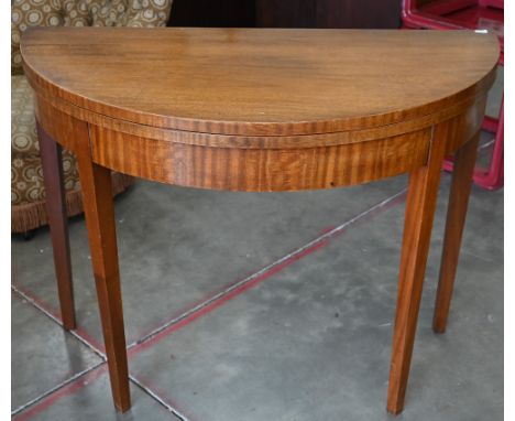 A mahogany demi-lune card table with folding baize lined top on tapering square supports, 96 cm w x 48 cm d x 74 cm h