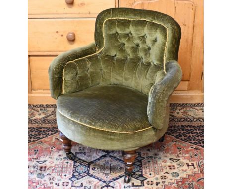 A Victorian green button backed tub salon armchair, raised on turned walnut legs to castors