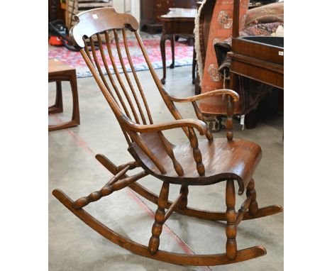 A vintage Danish stained pine spindle back rocking chair with scroll seat and bobbin turned supports 