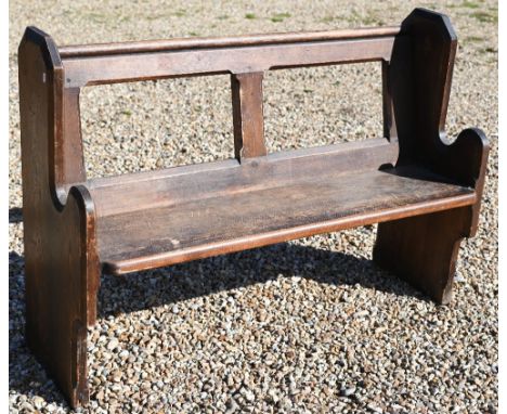 A dark stained pine church pew with open back, 130 cm w