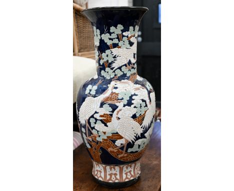 A large Asian ceramic baluster vase, embossed and painted with cranes on a dark blue ground, 80 cm high