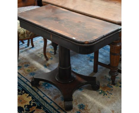 A Regency mahogany and rosewood cross banded folding card table with turned column and quadraform base on scroll feet, 94 cm 