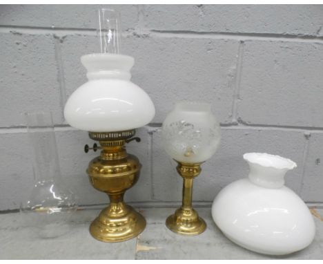 A paraffin lamp, a candle lamp and a glass chimney and shade **PLEASE NOTE THIS LOT IS NOT ELIGIBLE FOR POSTING AND PACKING**