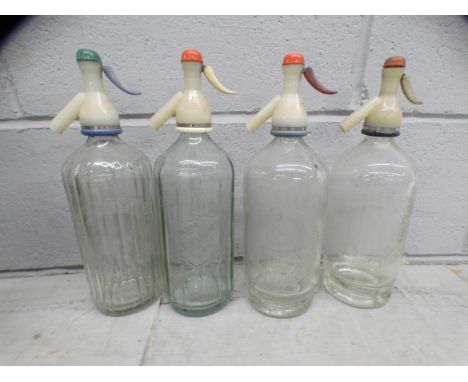 A collection of assorted glass bottles, mostly Victorian including medicine and some with labels, and four etched soda syphon