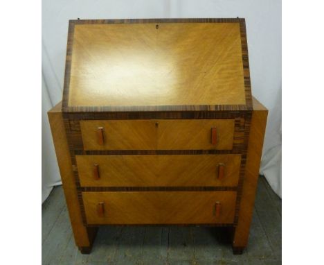 A rectangular Art Deco satinwood bureau with coromandel borders, three drawers with Bakelite handles on bracket feet