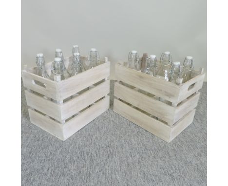 A vintage style wooden crate, containing glass bottles, together with another