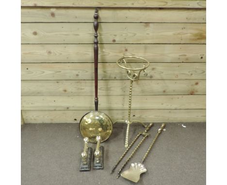 A pair of brass fire dogs, together with fire tools, a brass stand and a warming pan