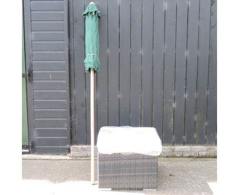 A large rattan coffee table with cushion, 64cm, together with a green garden parasol