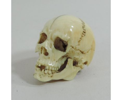 A 19th century Japanese finely carved ivory netsuke, in the form of a skull, 3cm tall
