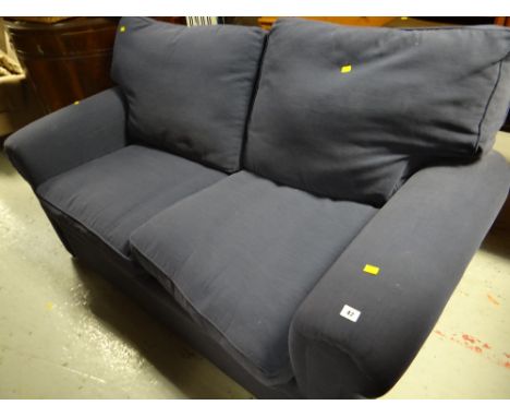 A modern two-seater blue fabric sofa bed