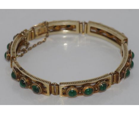 Vintage sectioned silver gilt bracelet set with pierced decoration and set with small green stones.. Stamped SILVER.