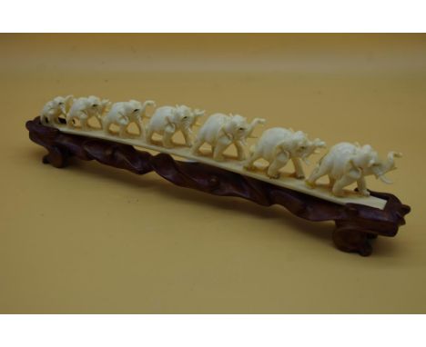 Early Indian ivory elephant figures chain of 7 elephants (as inspected, 1 elephant restored), on carved wooden stand. L25cms 