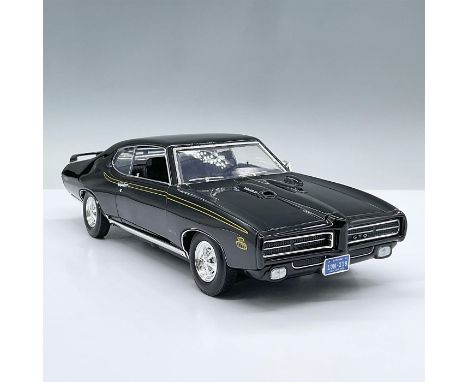 Sleek black model car with black interior, designed at a one eighteenth scale ratio. Movable parts include two doors, the hoo