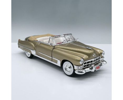 This superb golden model car has movable parts including, two doors, the hood, the trunk, two seats and a front wheel drive m