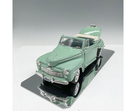 Die cast model car is 1/18 to scale colored in seafoam green with moveable parts including doors, trunk and hood. This item c