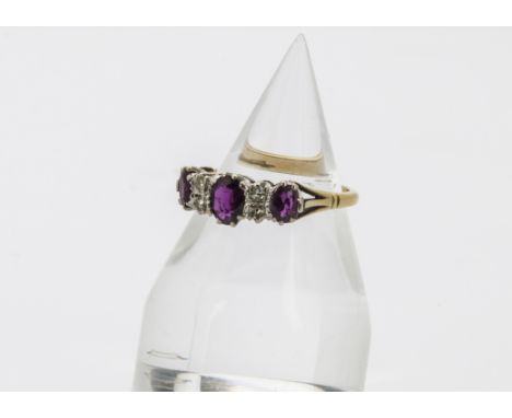 A vintage 18ct gold ruby and diamond ring, having the oval cut red stone and two pairs of small brilliant cuts, 4.5g and size