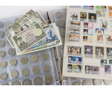 A collection of coins and stamps, including an album with modern two and one pound coins, 50p's and other coinage from Britai