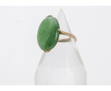 A vintage Chinese gold and jade signet or dress ring, the oval green hardstone panel in mount marked 18ct, 5.3g and size Mton