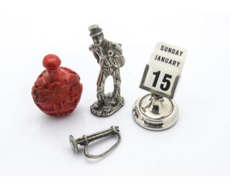 An Art Deco period silver desk calendar, together with a silver plated figure of a chimney sweep and a Chinese carved cinnaba