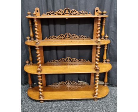 A 19th Century walnut waterfall four tier wall hanging shelf, having barley twist supports and fret carved back, urn and vase