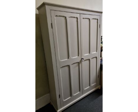 A modern pine sage green painted cabinet, having double doors to five shelf interior with row of hooks, on compressed bun fee