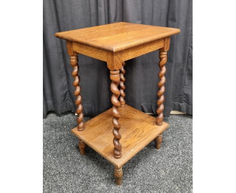 An oak two tier table, having rectangular top over barley twist supports with shelf under on tapered feet, 42.5cm x 37.5cm x 